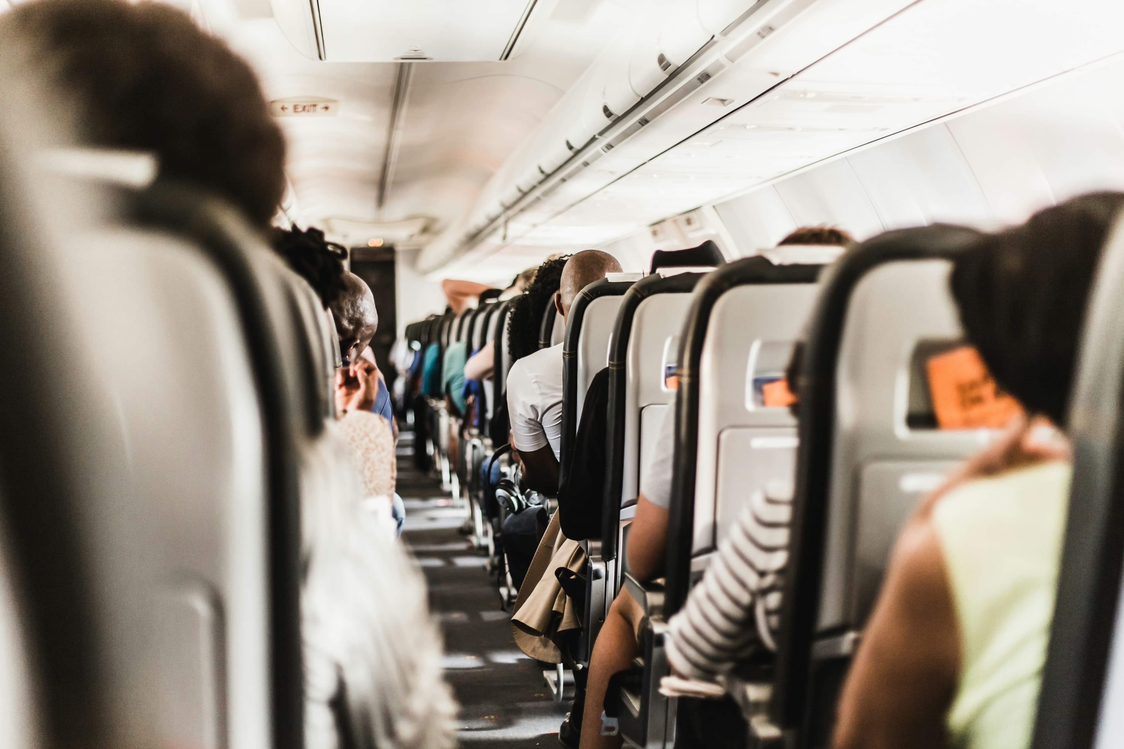 An aisle of passengers on a plane