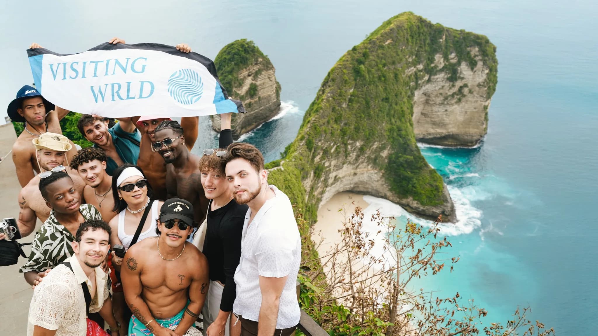 The group with the Visiting Wrld banner above Kelingking Beach, Bali