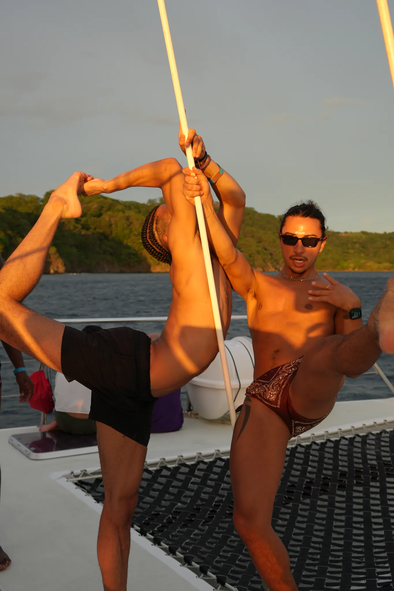Partner stretch on the bow at sunset