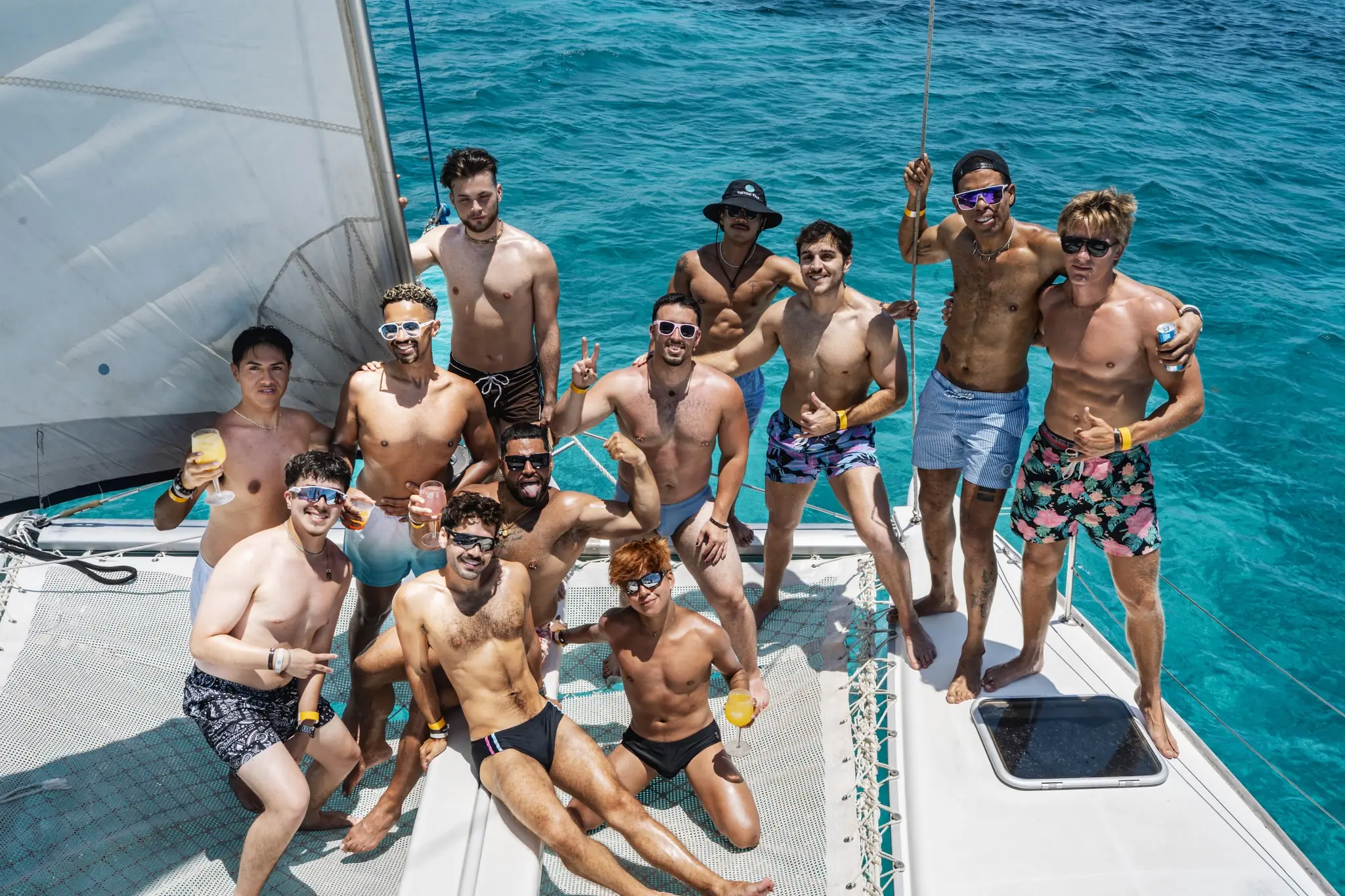The crew on the catamaran bow over turquoise water