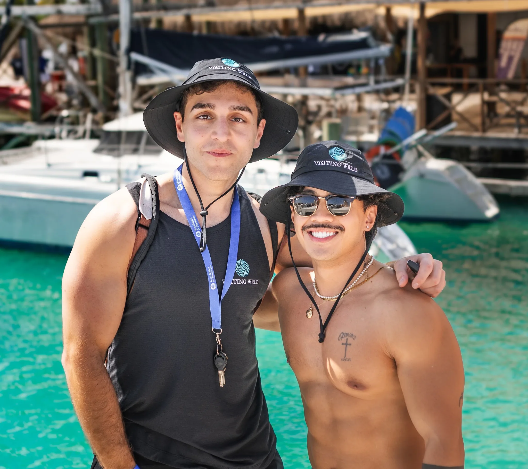 Two friends in Visiting Wrld hats before the boat day