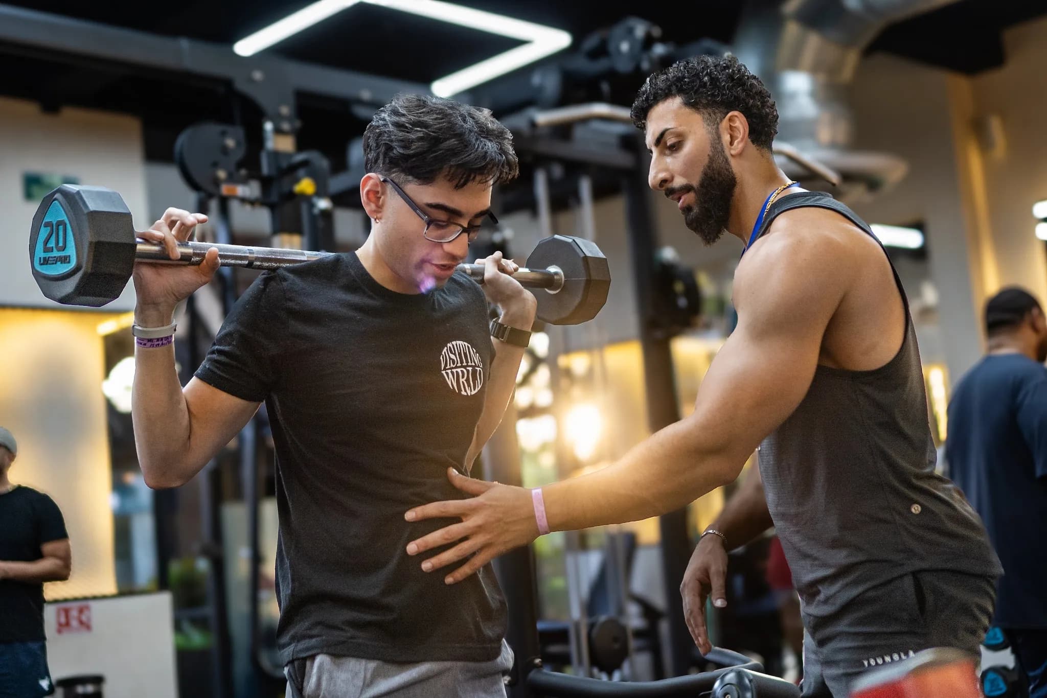 A coach checking squat form during a training session