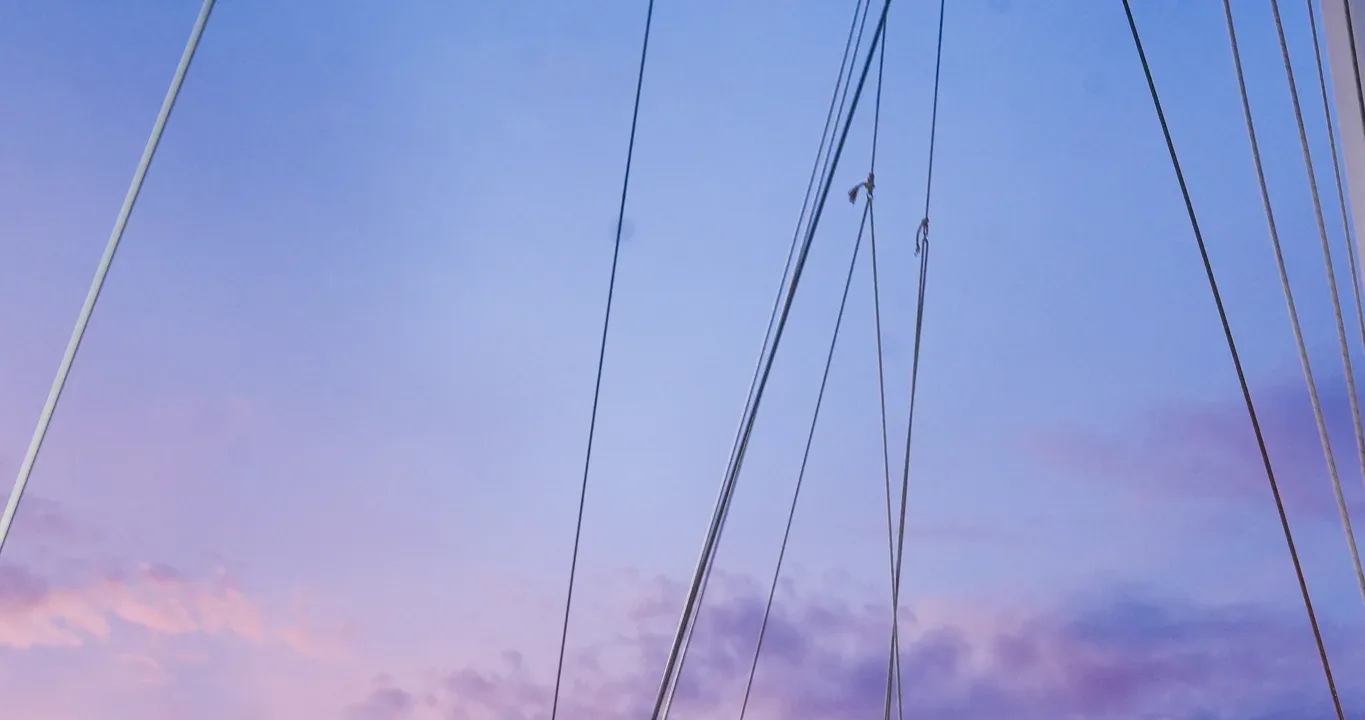 Pink and violet sunset sky through the sail rigging on a Visiting Wrld boat day