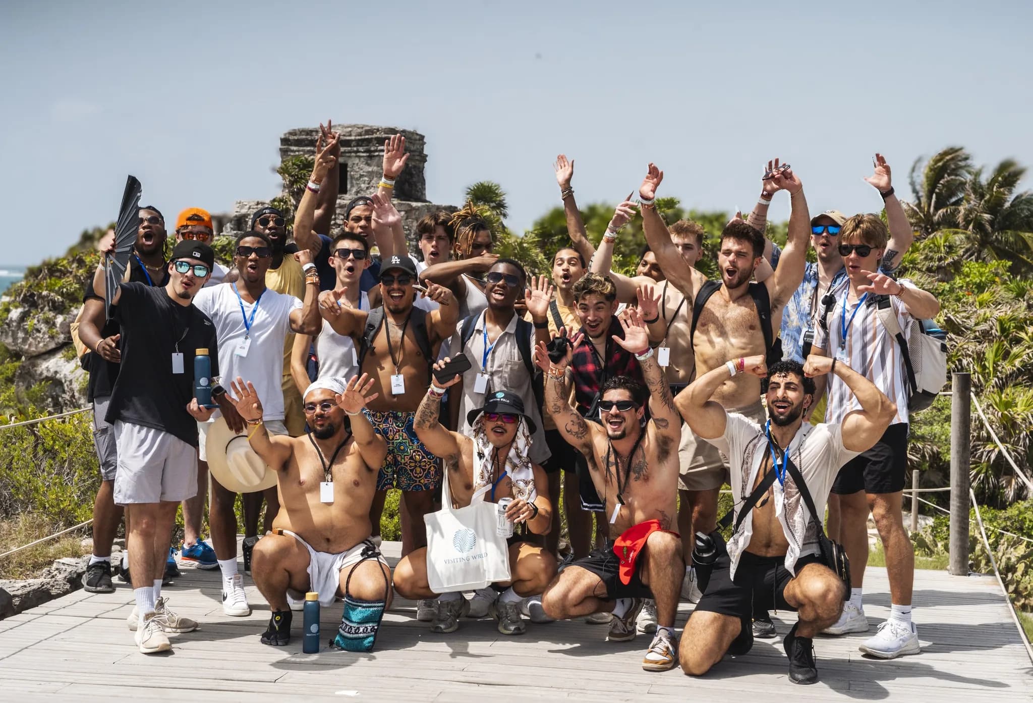 A Visiting Wrld retreat group cheering together in front of the Tulum ruins in Mexico