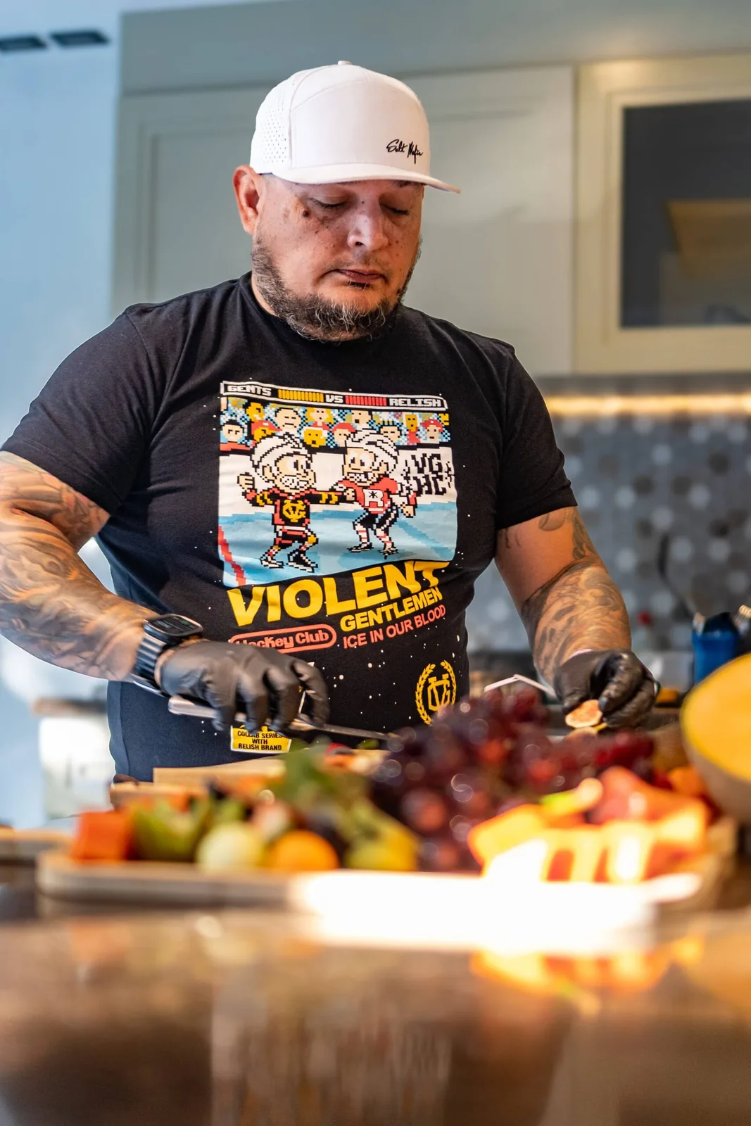 A chef preparing a fresh fruit platter in a modern kitchen, focused on presentation and quality