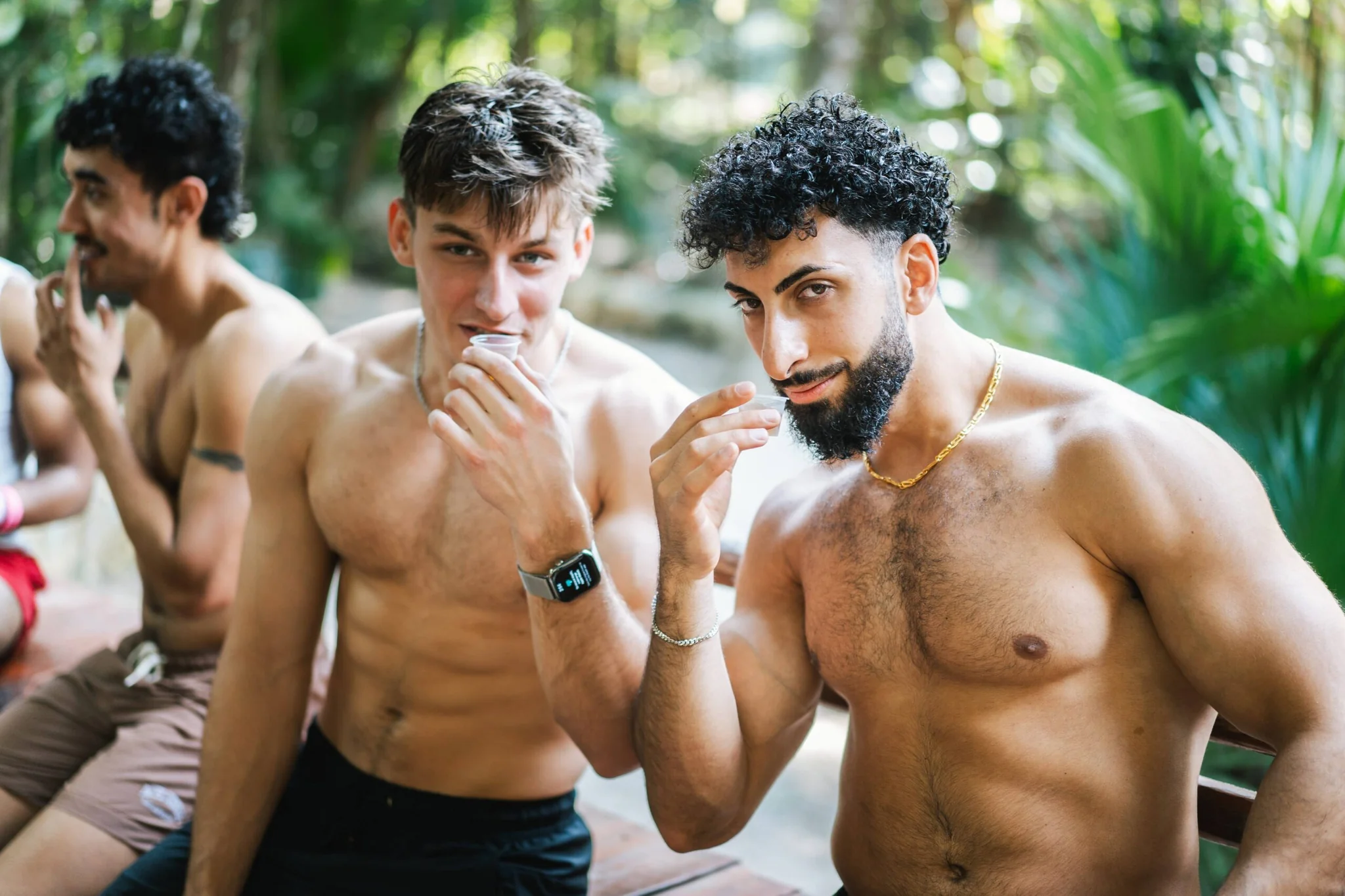 Two retreaters toasting with small cups at a jungle cenote near Playa del Carmen
