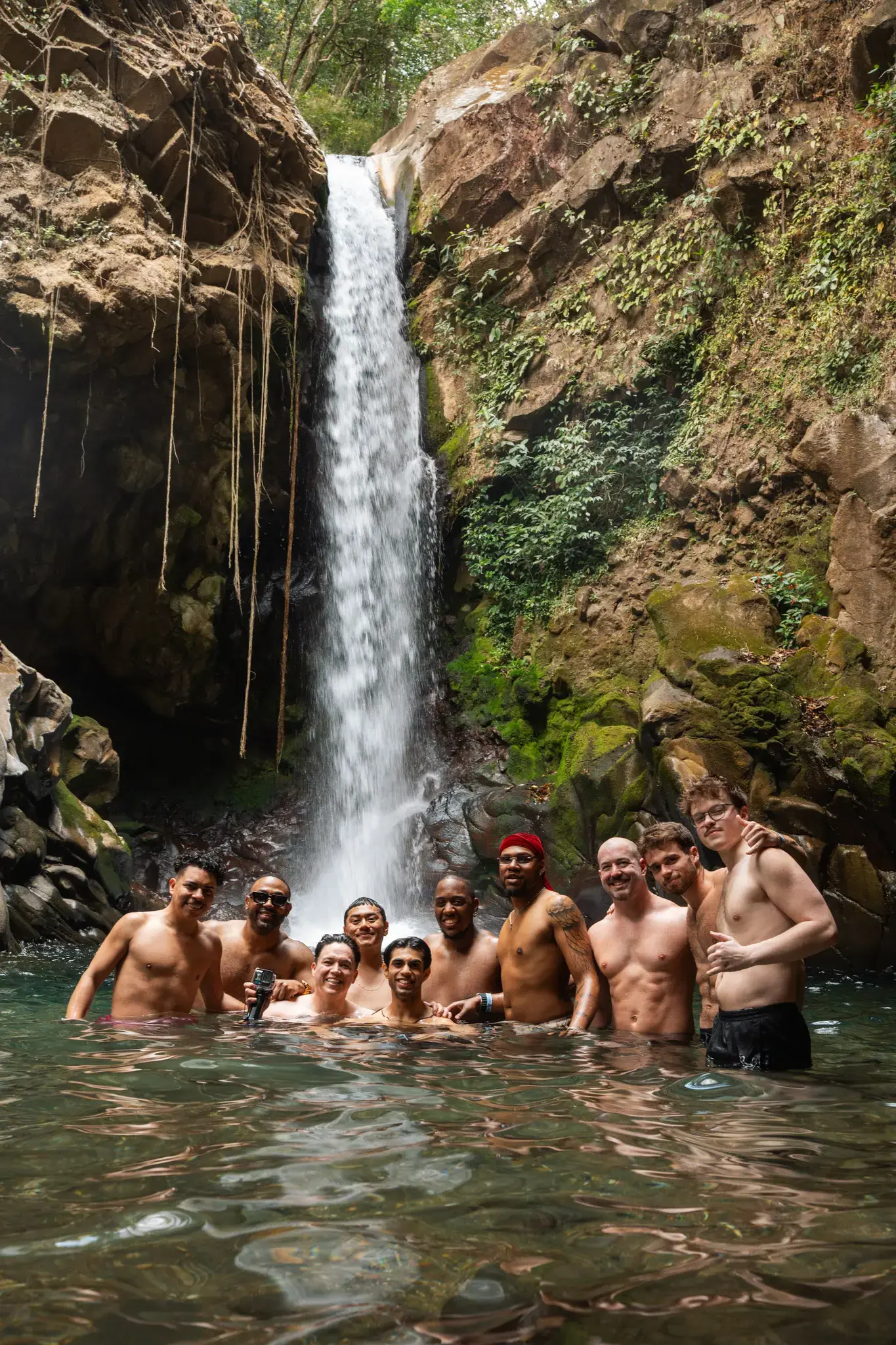 A Visiting Wrld retreat group swimming at the base of a waterfall in Guanacaste, Costa Rica