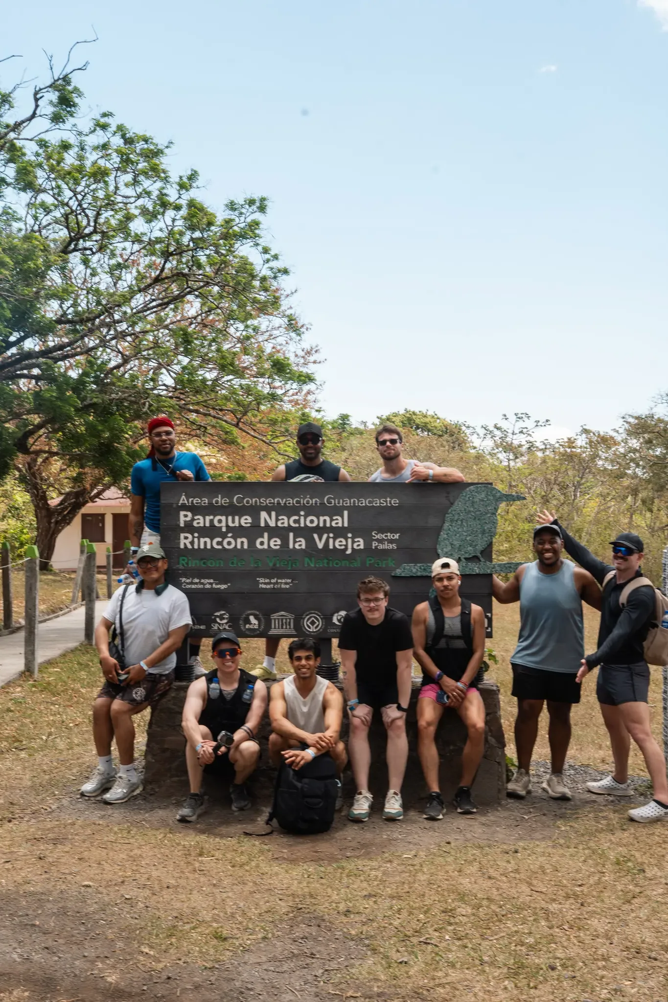 Retreaters gathered around the Rincón de la Vieja National Park sign in Guanacaste, Costa Rica