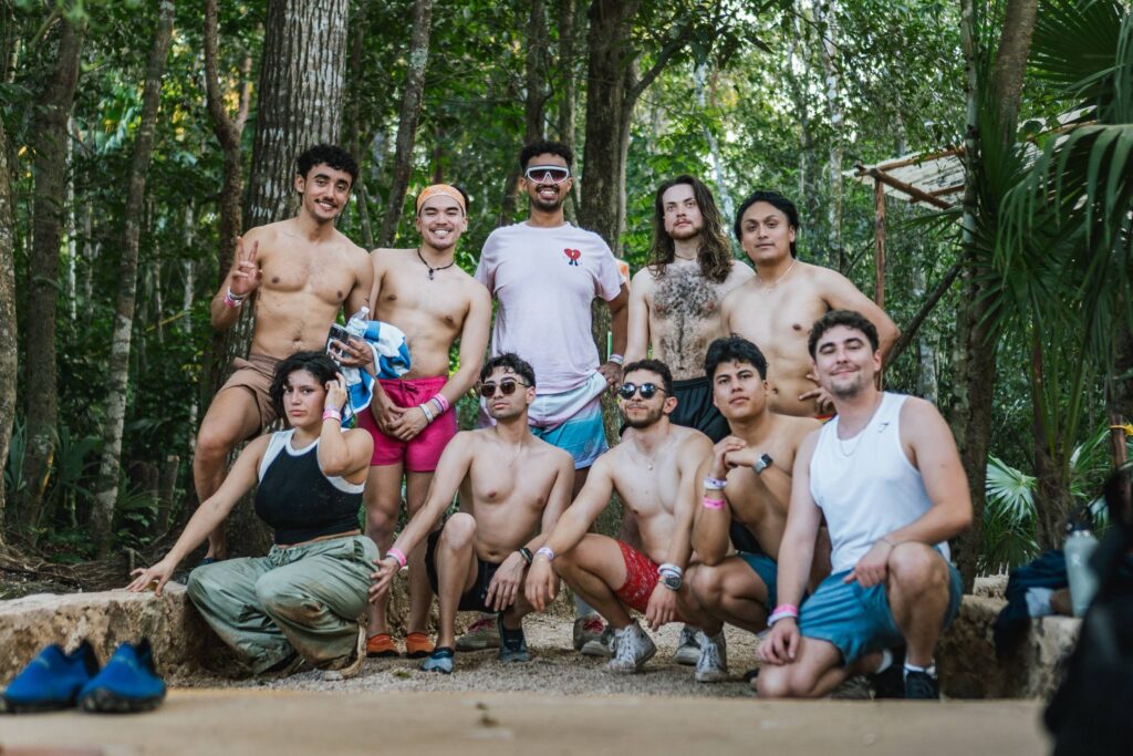 Group of LGBTQ+ fitness retreat attendees posing in a scenic jungle setting